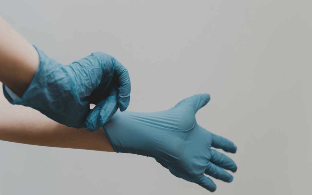 A doctor putting on medical gloves.